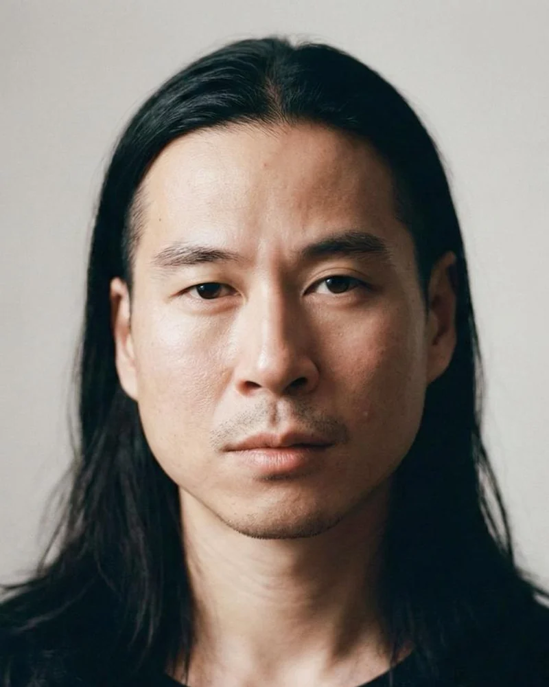 Christopher So, senior barber and educator at The Cave, wearing his dark hair long and loose